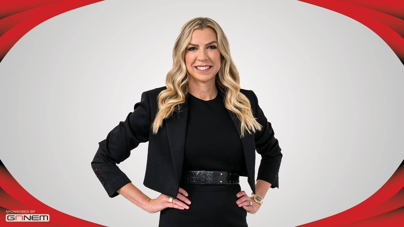 Image of a person in an all black outfit smiling and standing with their hands on their hips.